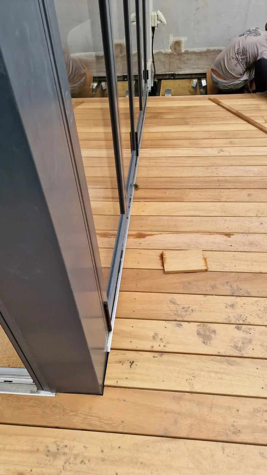Decking board scribed tightly around a bifold door threshold